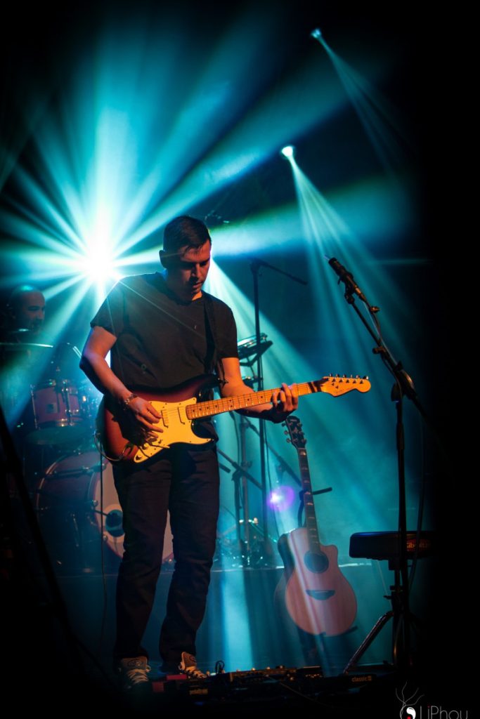 Guitariste de F•L•O•Y•D éclairé par des faisceaux bleus